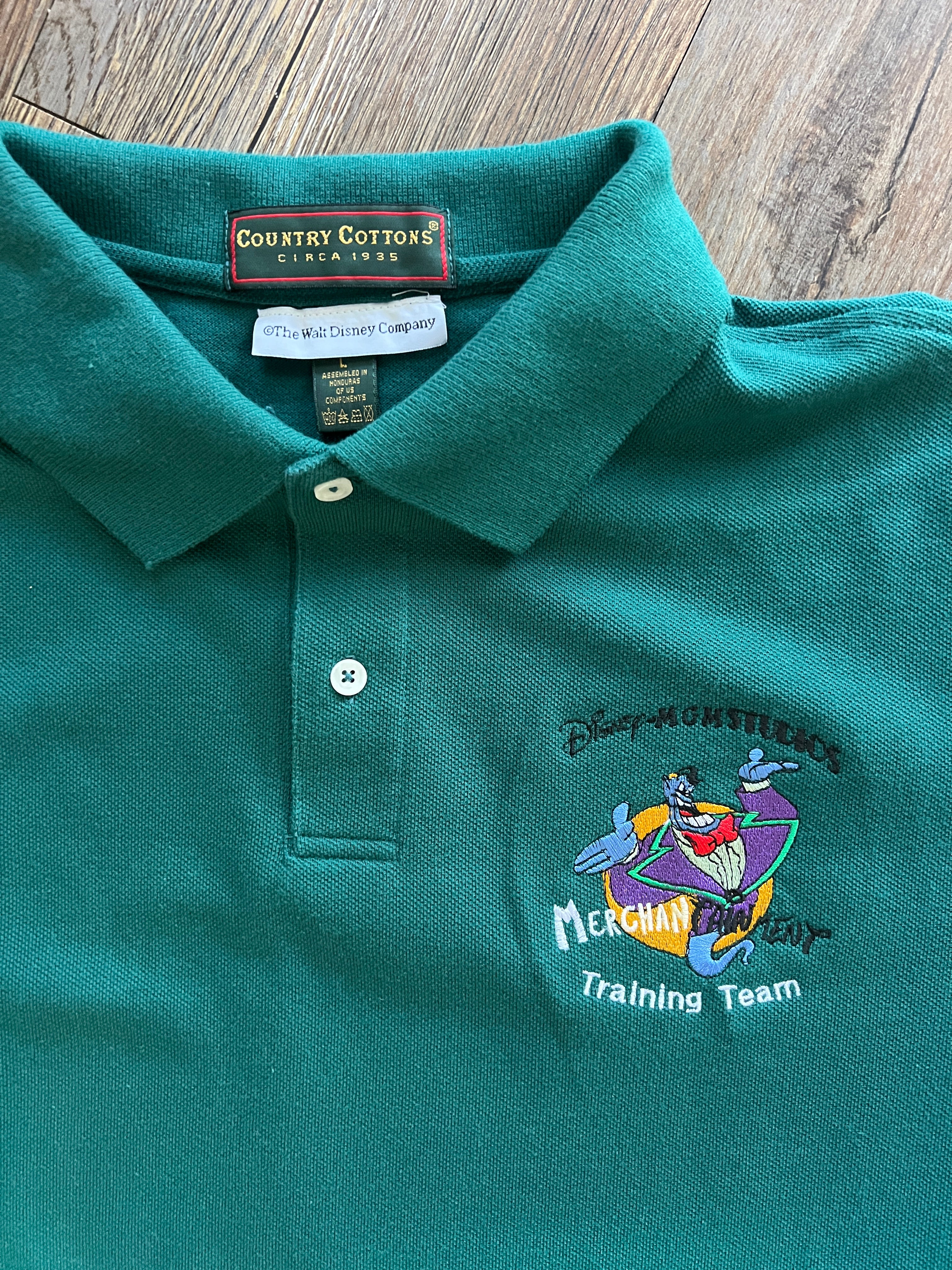 1249 -Green Genie MGM Studios Merchantainment Training Team Polo - L